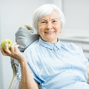 senior woman holding an apple 
