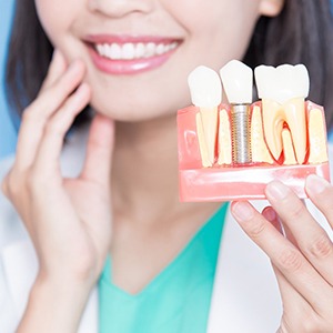 dentist holding dental implant in Conroe